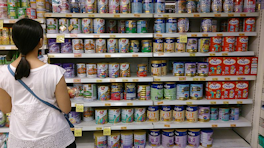 lady-shopping-comparing-cans-grocery-aisle-posted-cutting-edge-blog-mhmsm-com.png
